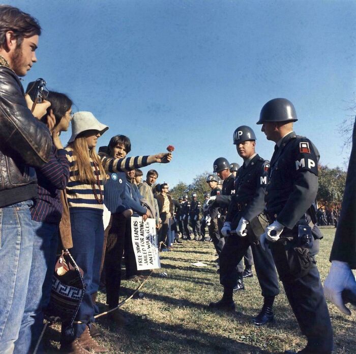 Protesters offering flowers to military police in a historical demonstration, symbolizing peace and resistance.