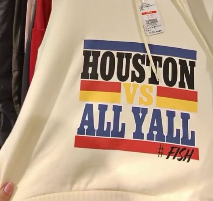 Poorly translated shirt in Japan with text "Houston VS All Yall" and hashtag "#FISH" in bold colors.