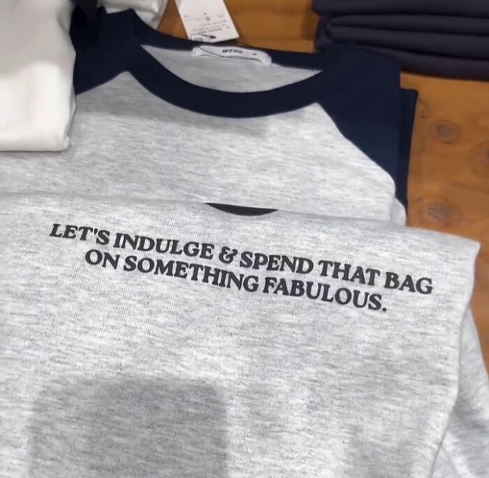 Gray shirt in Japan with bold text: "LET'S INDULGE & SPEND THAT BAG ON SOMETHING FABULOUS."