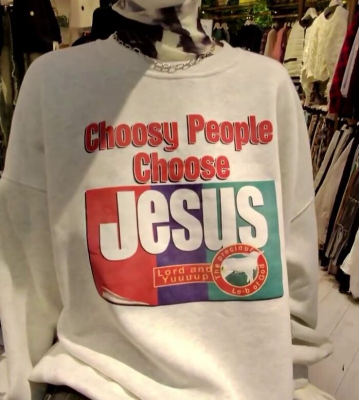 Shirt with "Choosy People Choose Jesus" text in a clothing store, featuring colorful design elements.