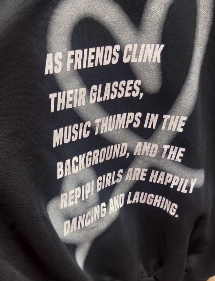 Black shirt with white text reading an awkward translation about friends clinking glasses and dancing, found in Japan.