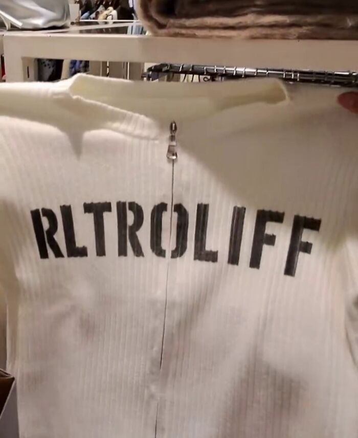 White shirt in Japan with poorly translated text "RLTROLIF" printed in black across the back.