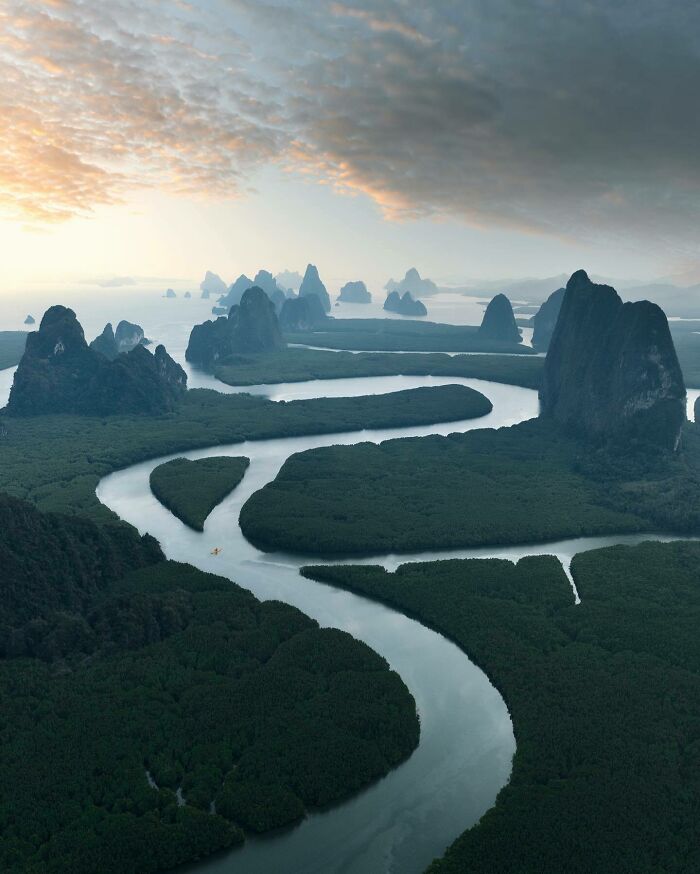 Aerial photo showcasing winding rivers and lush green landscapes under a dramatic sky.
