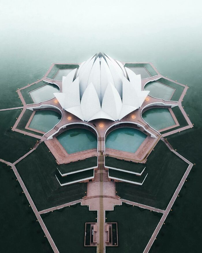 Aerial view of a lotus-shaped structure surrounded by water, showcasing architecture from a different angle.