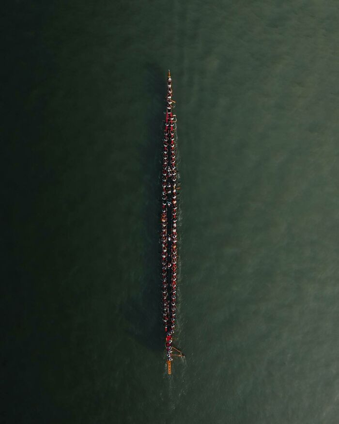 Aerial photo of a long, narrow boat with rowers, showcasing the world from a different angle.
