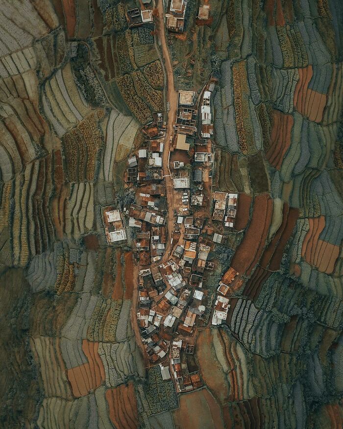 Aerial photo of a village surrounded by colorful patchwork of fields showing the world from a different angle.