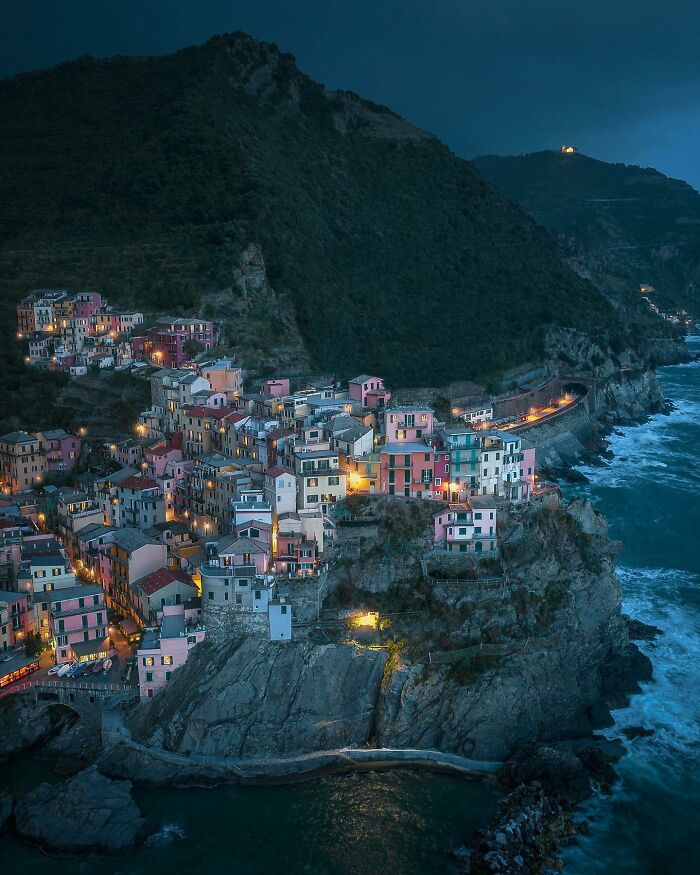 Aerial view of a colorful coastal village illuminated at night, showcasing the world from a different angle.