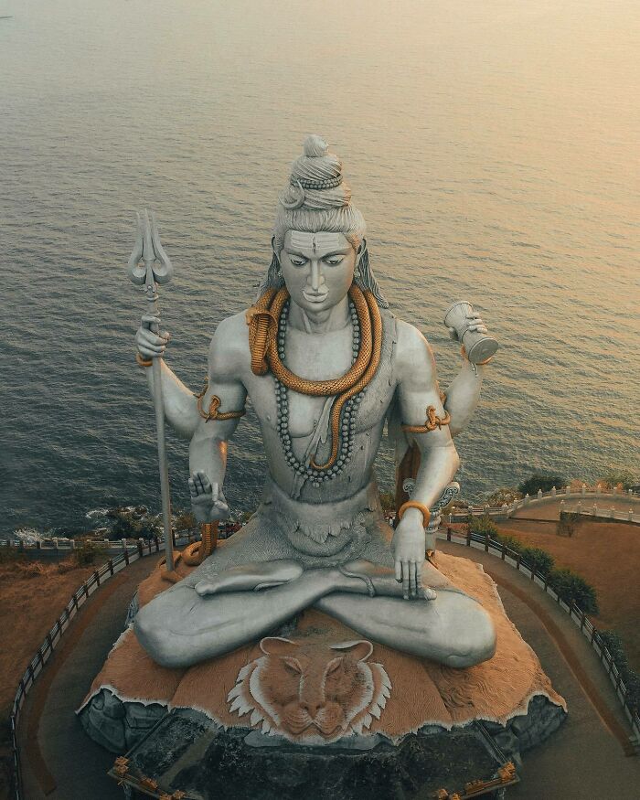 Aerial view of a large Shiva statue by the sea, showcasing a different angle of the world.