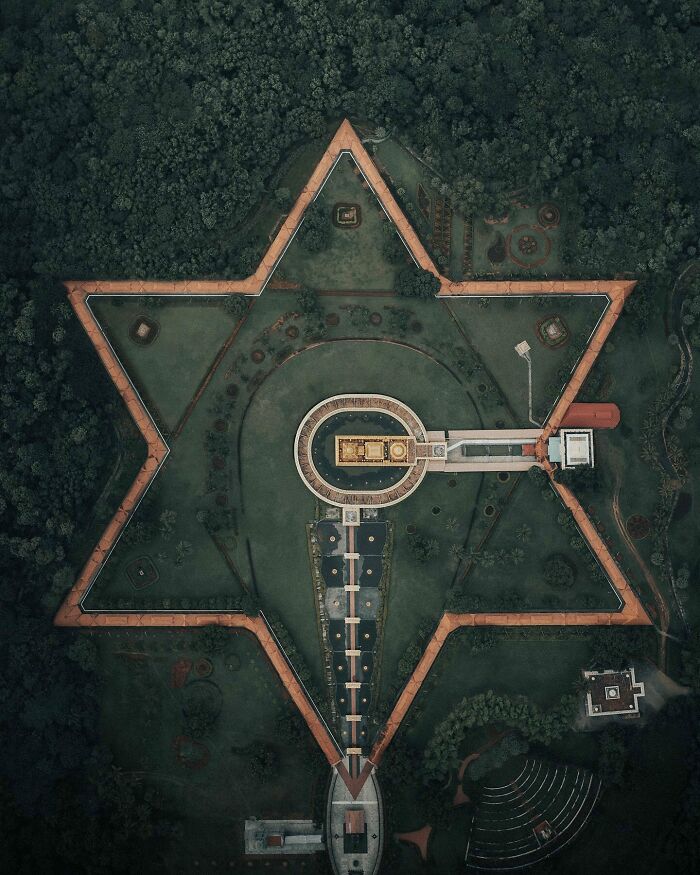 Aerial photo of a star-shaped garden structure surrounded by dense greenery.