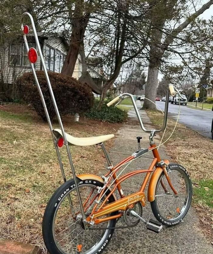Vintage bicycle with banana seat and tall sissy bar parked on a sidewalk, evoking nostalgia and feelings of being old.