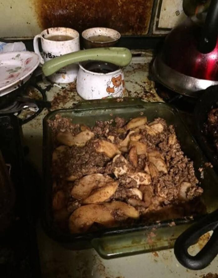 A potluck dish with unappetizing appearance on a cluttered, dirty kitchen counter.