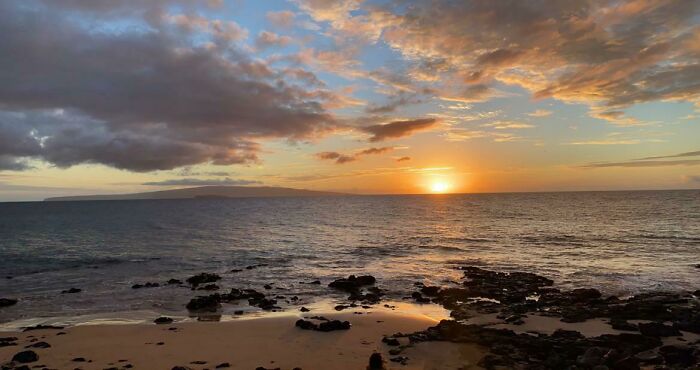 Scenic ocean view at sunset, colorful sky reflections, peaceful seascape.