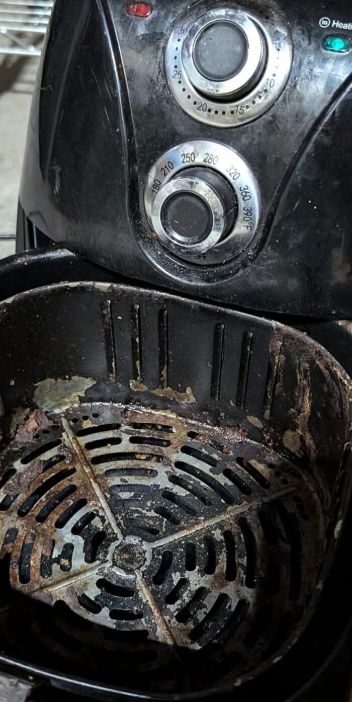 Dirty air fryer with food residue, highlighting worst dishes from potlucks.