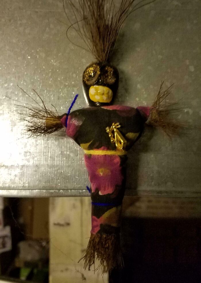 Creepy doll with a painted face and colorful cloth body, found hidden in a home.