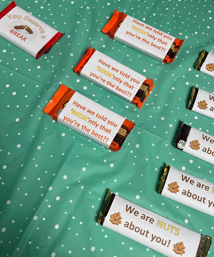 Candy bars with humorous notes for ineffective bosses, arranged on a green polka dot tablecloth.