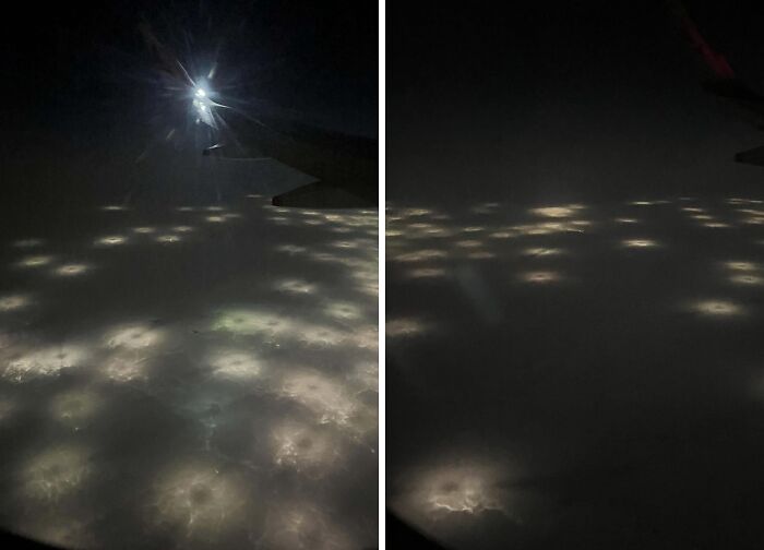 Mysterious glowing lights spotted in the ocean viewed from an airplane window at night.