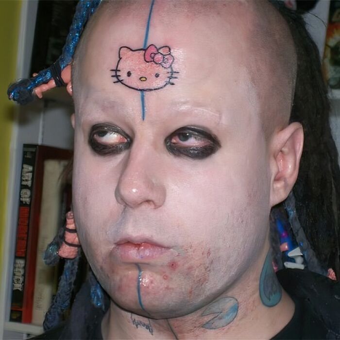 Man with tattoo mistake featuring Hello Kitty on his forehead, heavy eye makeup.