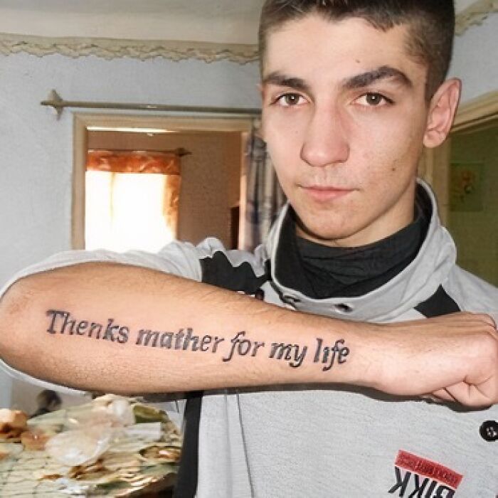 A person displays a tattoo on their arm with a spelling mistake.
