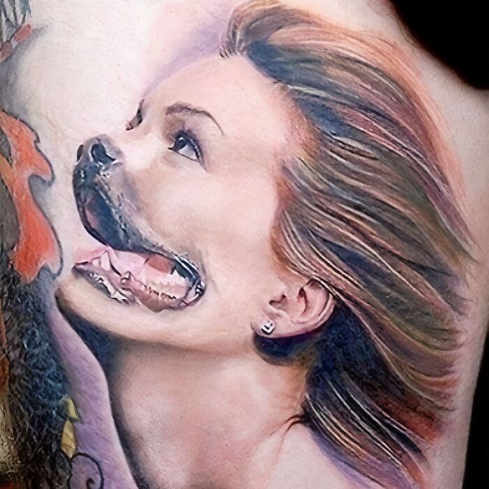 Tattoo with a face blending human and dog features, showcasing a permanent mistake in body art.
