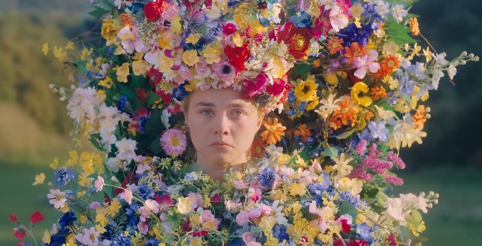 Actor surrounded by vibrant flowers, showcasing dedication and effort for difficult roles in a challenging acting performance.
