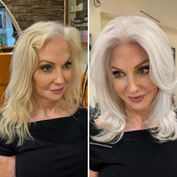 Woman embracing natural gray hair transformation, wearing a black top in a salon setting.