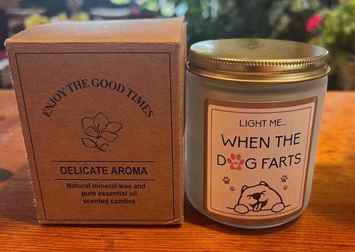 Candle with humorous label: "Light me when the dog farts" beside a box labeled "Delicate Aroma."