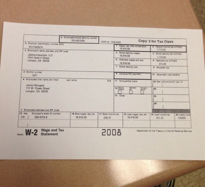 W-2 tax form on a beige surface, highlighting employment details for tax purposes in American schools.