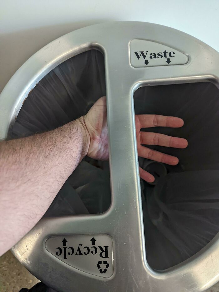 Hand stuck in a poorly designed recycling bin showing city planners' oversight.