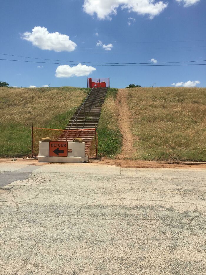 Detour sign blocks stairway on hill; unclear city planning decision evident.