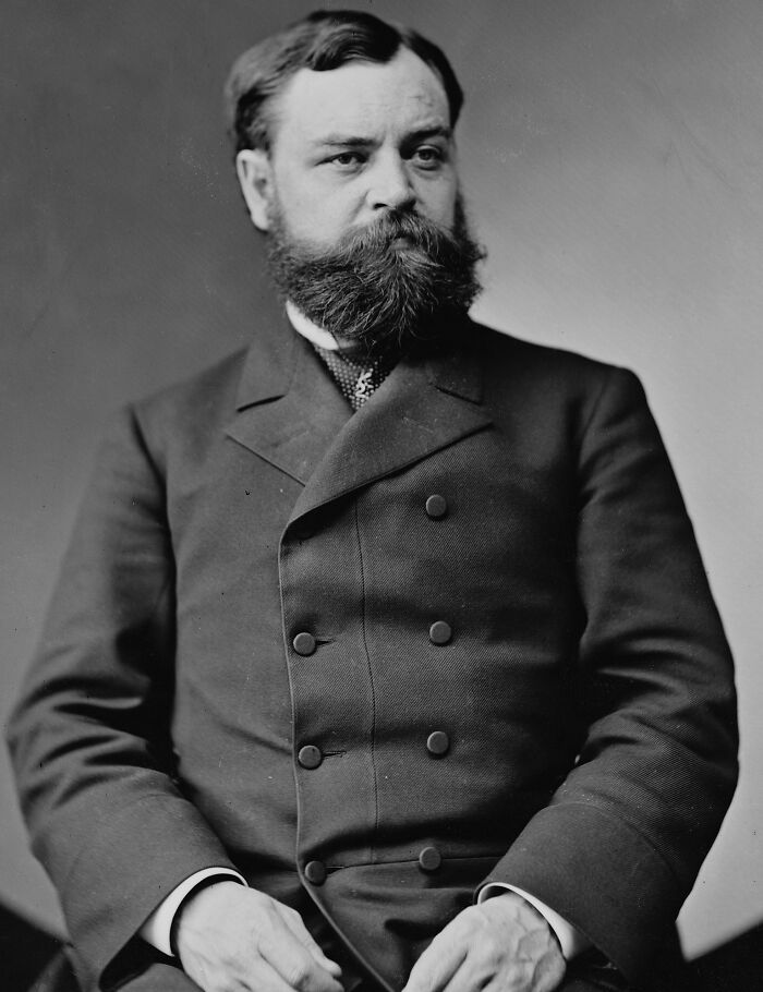 Man in 19th-century attire posing for a formal portrait, symbolizing historical coincidences.