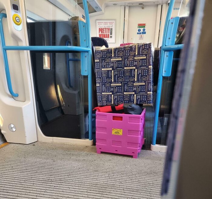 Pink crate blocking train door, showing lack of basic etiquette.