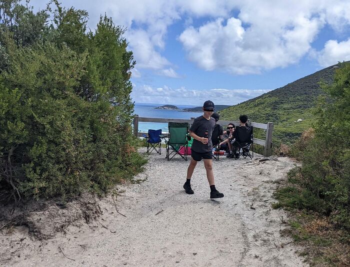 Group blocking scenic path with chairs, showing lack of etiquette in nature setting.
