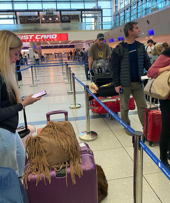 Airport queue showing people with luggage, illustrating a lack of basic etiquette.