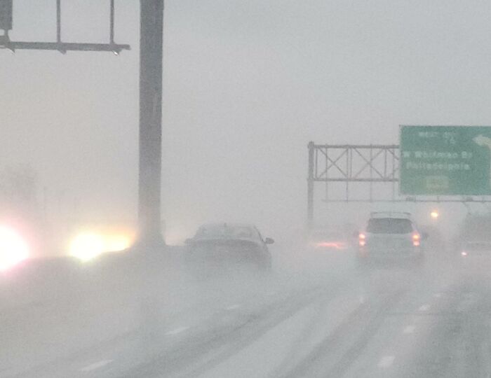 Cars driving in heavy fog, demonstrating a lack of road etiquette by not using headlights.