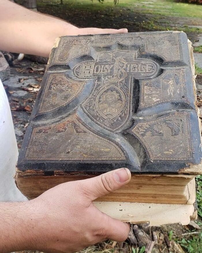 Person holding an antique Holy Bible, one of the creepy things found hidden in homes.