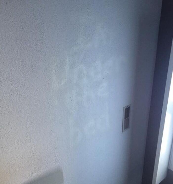 Ghostly writing on a wall, suggesting something creepy was found hidden in the home.