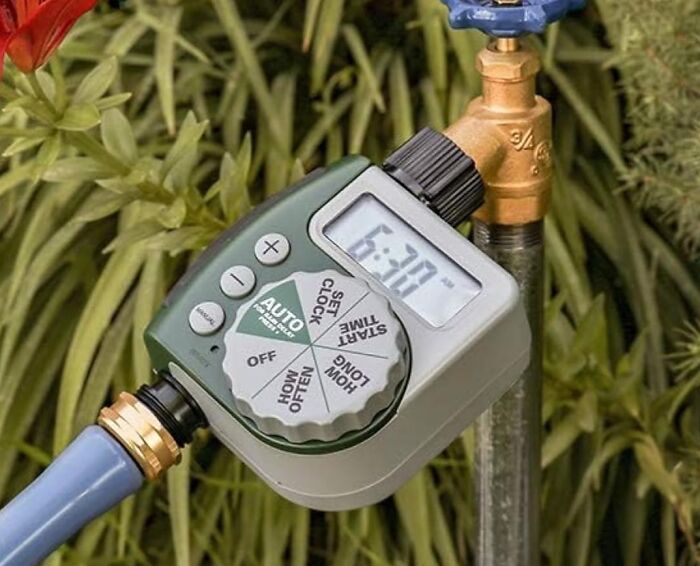 Automatic garden water timer attached to a faucet, perfect for a gardening style focused on benign neglect.