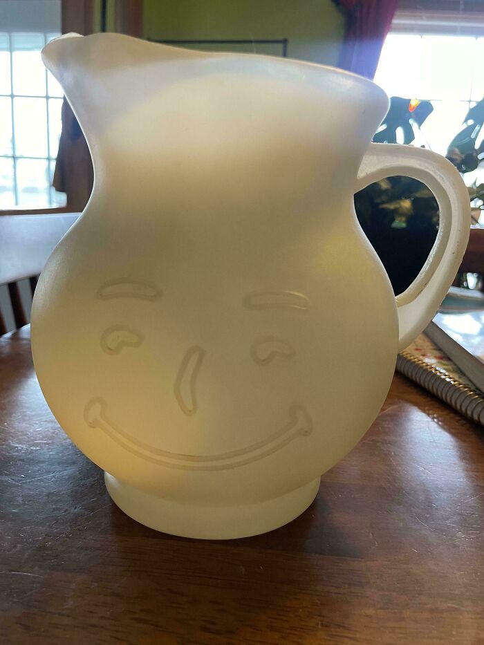 Smiling face jug found as a hidden gem at Goodwill, placed on a wooden table.