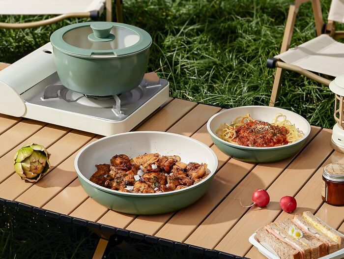 Green cookware set with trendsetting treasures on a picnic table, featuring delicious dishes and vibrant ingredients.