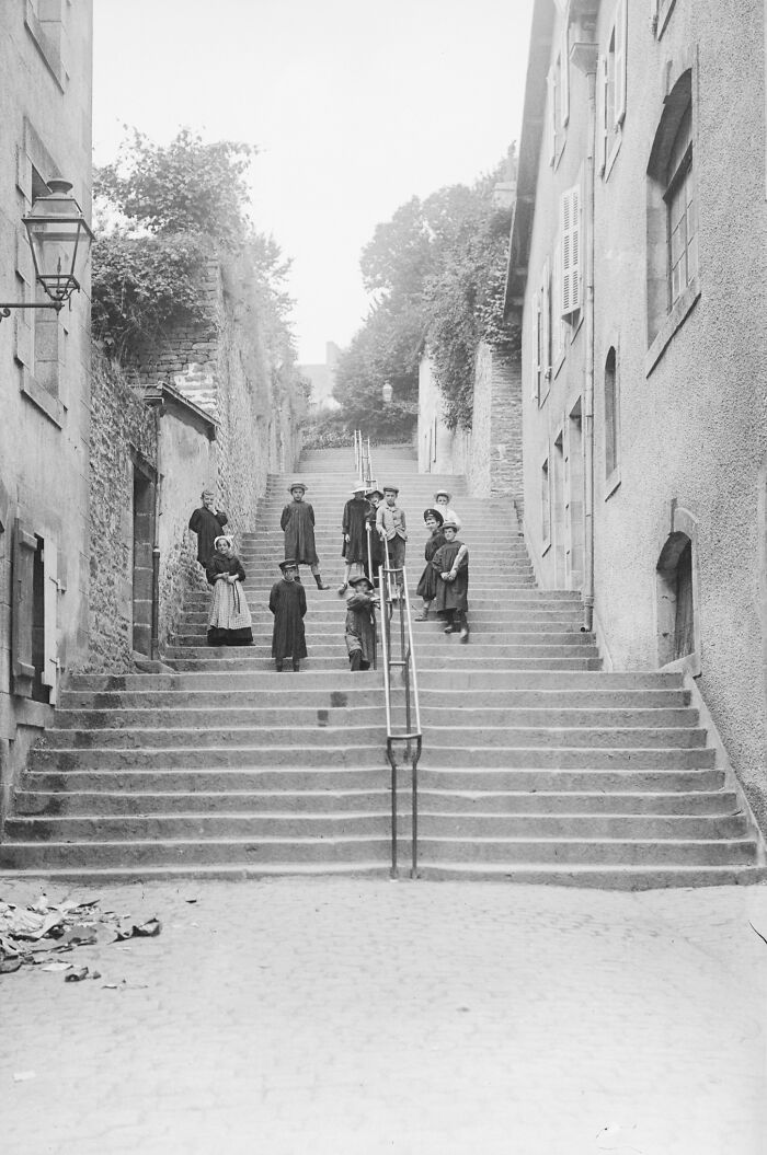 Children and adults posing on a long stone stairway in Europe showing life in Europe 100 years ago.