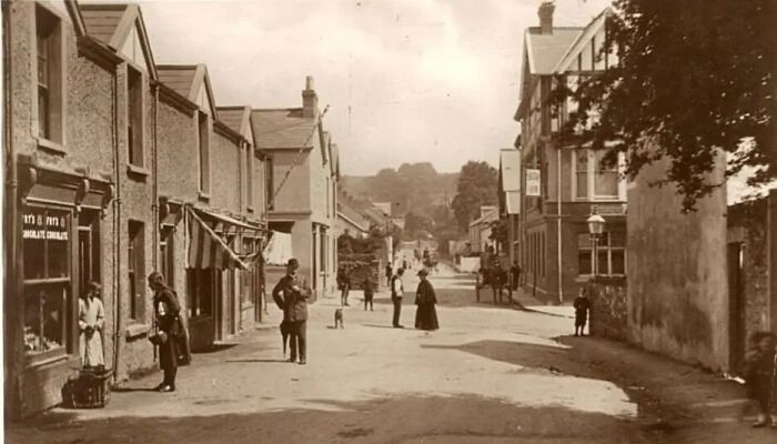 Street scene in Europe 100 years ago showing people, buildings, and daily life in a historic European town.