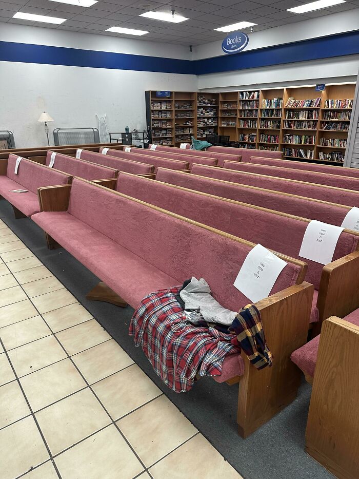 Pews displayed in a Goodwill store aisle with bookshelves in the background, showcasing unique hidden gems.