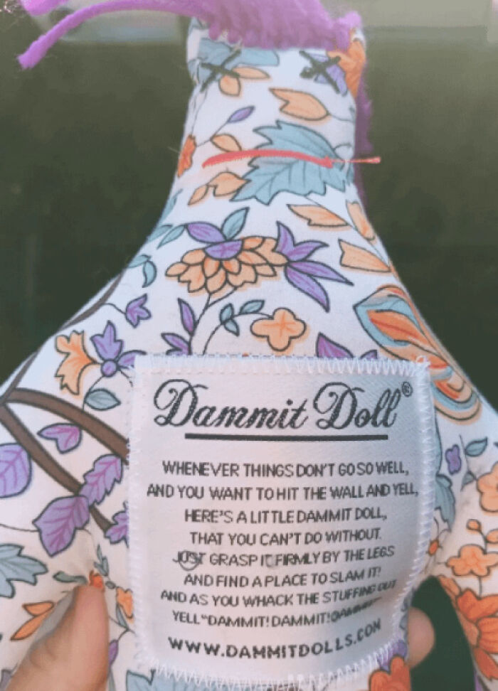 Floral Dammit Doll with humorous tag from Goodwill's hidden gems collection.