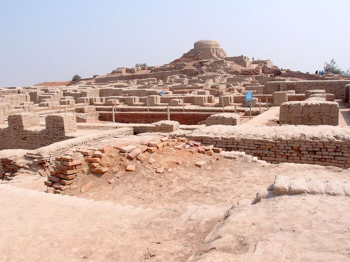 Ruins of an ancient architectural wonder with brick structures under a clear sky.