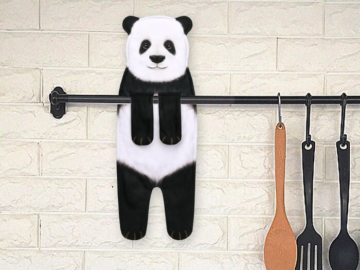 Panda-themed kitchen towel hanging on a rack next to cooking utensils.
