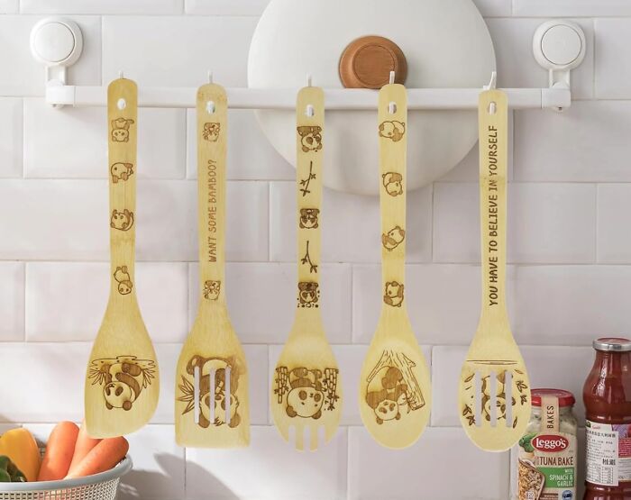 Bored Panda-themed bamboo utensils hanging in a kitchen, featuring cute illustrations and motivational quotes.