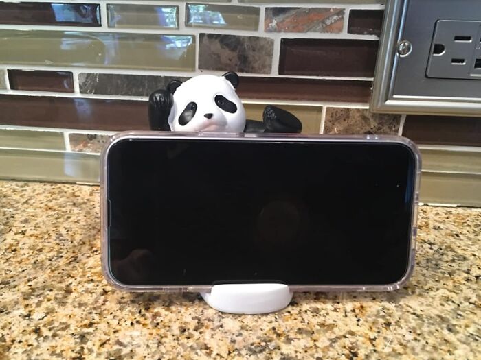 Panda phone holder on kitchen counter with smartphone in place, showcasing a playful touch of boredom.