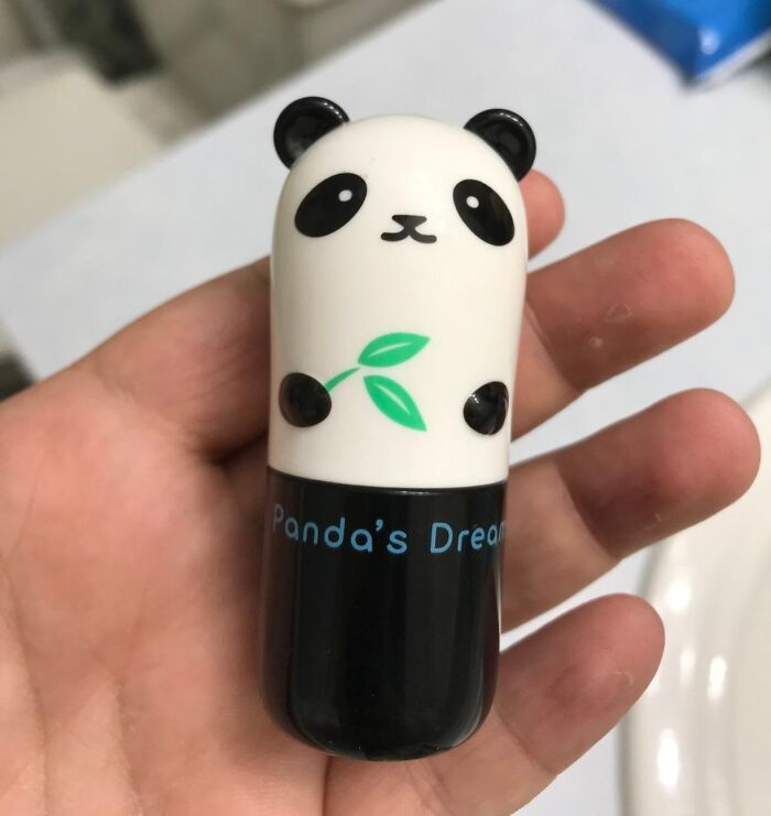 Hand holding a small panda-shaped object labeled "Panda's Dream," related to the Bored Panda children's book.
