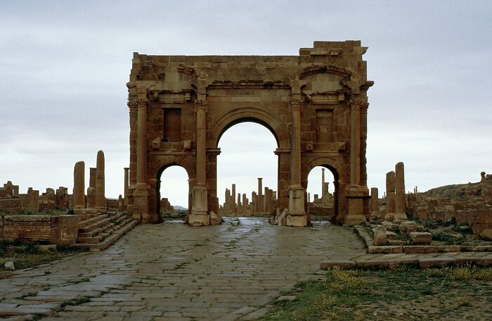 Ancient stone arch amidst ruins, illustrating an architectural wonder not widely known.