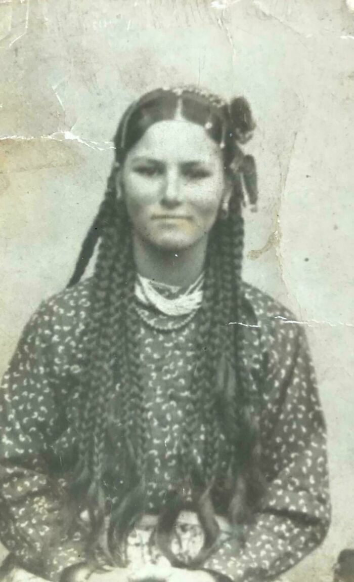 Mujer con trenzas largas en foto antigua que representa fotos de hace décadas elocuentes y memorables.